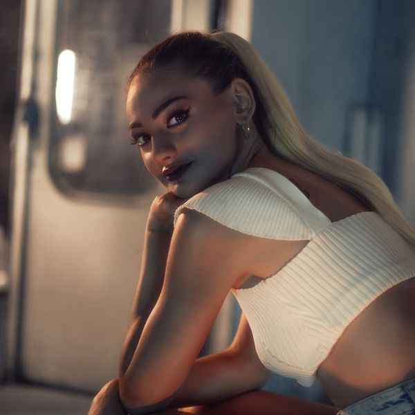 Portrait of a smiling, confident woman named Alina against a dark background.